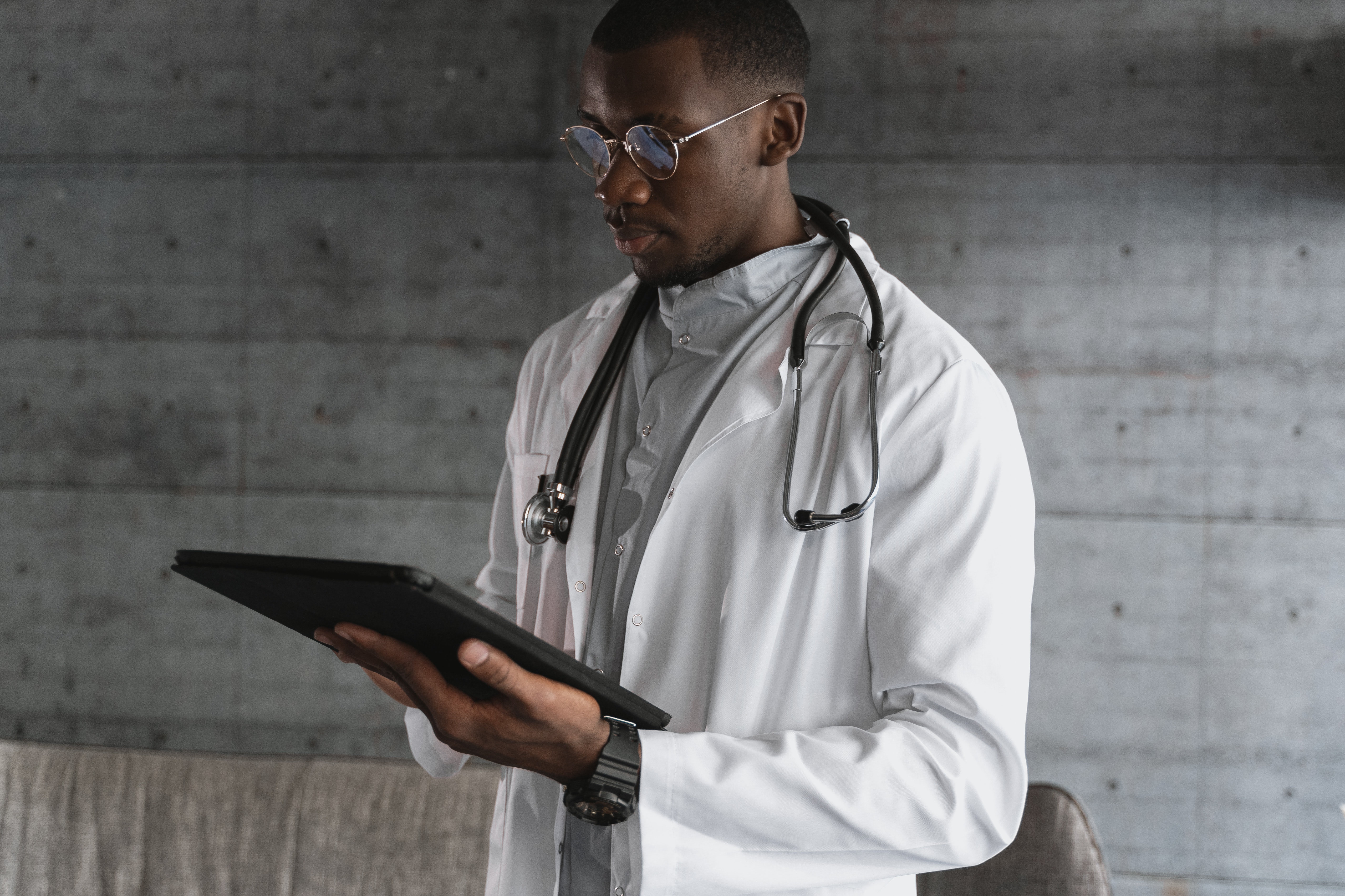 Doctor in white coat with stethoscope and electronic tablet